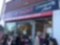 People gather at the Community Hub's shop window for it's opening ceremony.